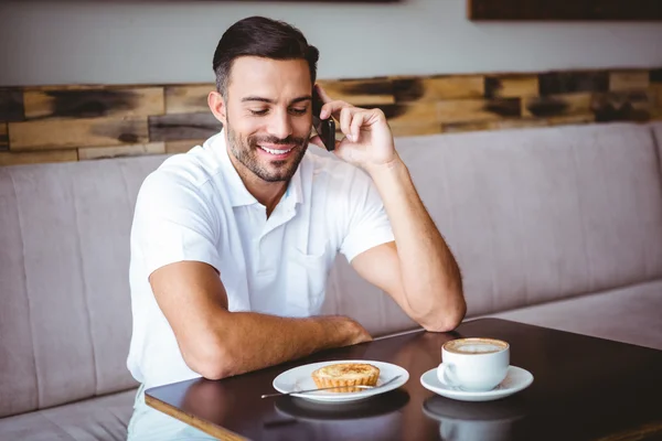 Mladý muž s úsměvem na telefonu — Stock fotografie