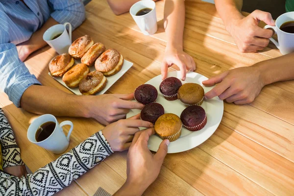 Gente de negocios tomando pasteles en la mesa — Foto de Stock