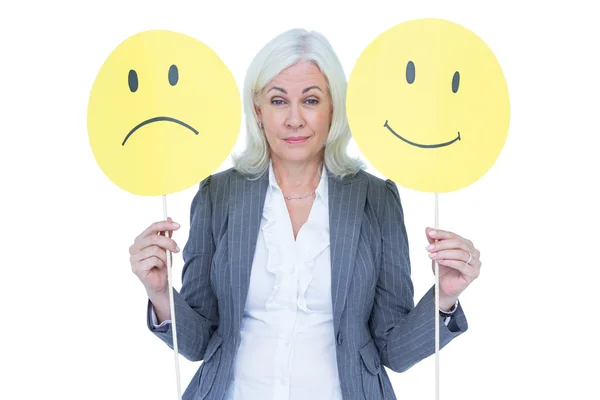 Affärskvinna håller sorgligt och en glada smileys — Stockfoto