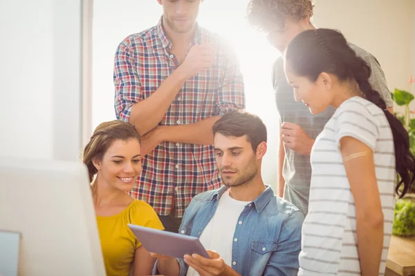 Equipo empresarial creativo reunido en torno a una tableta — Foto de Stock