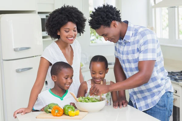 Família feliz preparando legumes juntos — Fotografia de Stock