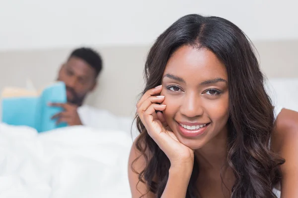 Mujer bonita sonriendo a la cámara en la cama — Foto de Stock