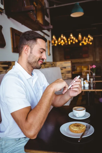 Joven tomando una taza de café y pastelería — Foto de Stock