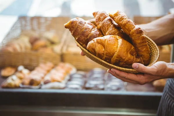 Gelukkig werknemer houden een mandje van croissant — Stockfoto