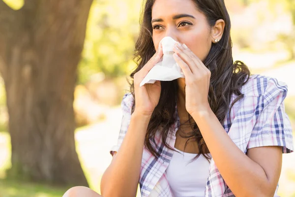 Pretty brunette blowing her nose — Stock Photo, Image