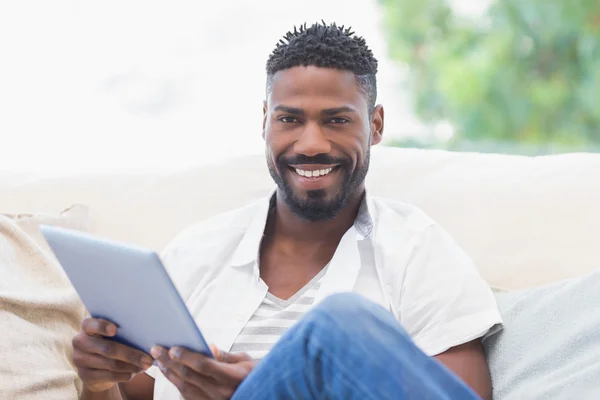 Homme utilisant sa tablette sur le canapé — Photo