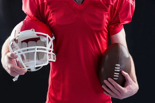 Jogador de futebol tomando um capacete e bola em sua mão — Fotografia de Stock