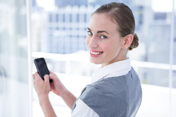 Empresaria de mensajes de texto con su teléfono inteligente —  Fotos de Stock