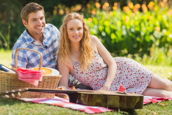 Kameraya bakarak bir piknik üzerinde genç Çift — Stok fotoğraf