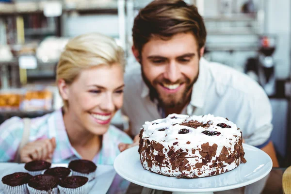 Linda pareja en una cita mirando un pastel de chocolate — Foto de Stock