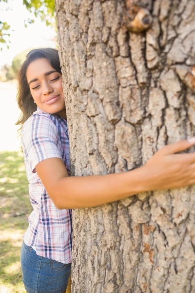 Bonita morena abrazando árbol — Foto de Stock