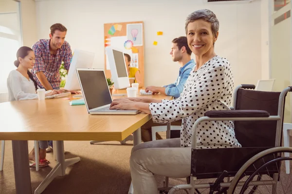 Creative casual businesswoman in wheelchair — Stock Photo, Image