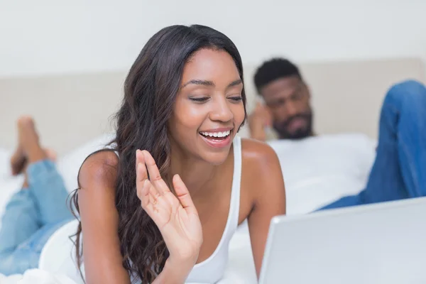 Entspannte Frau mit Laptop im Bett — Stockfoto