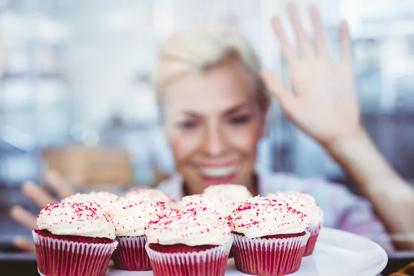 Verbaasd mooie vrouw kijken naar cup cakes — Stockfoto