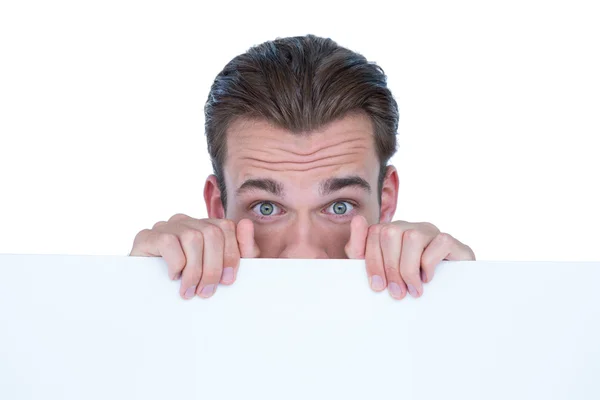 Man hiding by blank paper Stock Picture