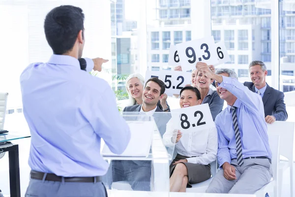 Lächelndes Wirtschaftsteam zeigt Papier mit Bewertung — Stockfoto