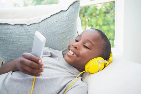 Mały chłopiec słuchanie muzyki na kanapie — Zdjęcie stockowe