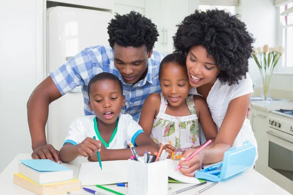 Happy parents helping children with homework — Stock Photo, Image