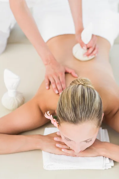 Blondin njuter av en växtbaserade komprimerar massage — Stockfoto