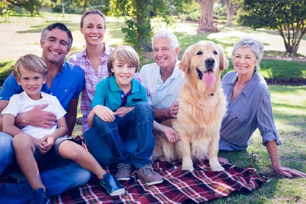 Счастливая семья улыбается в камеру со своей собакой — стоковое фото