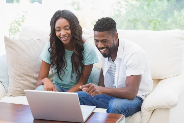 Happy couple on the couch using laptop — Stock Photo, Image