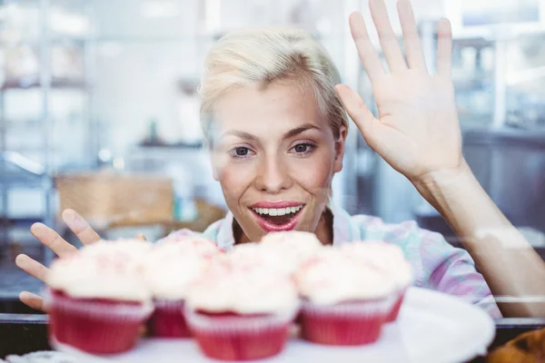 Mujer bonita asombrada mirando tortas de la taza — Foto de Stock