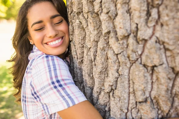 Mooie brunette knuffelen boom — Stockfoto