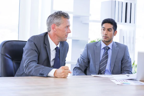 Reunión de hombres de negocios con un colega que usa un portátil —  Fotos de Stock