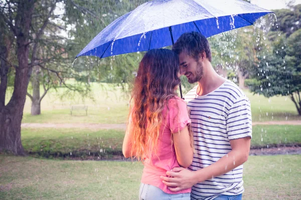 Couple hugging under the umbrella — Stock Photo, Image