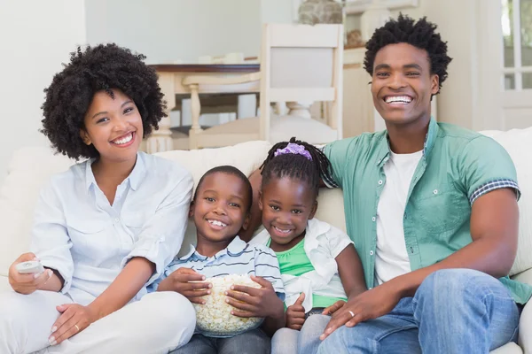 Familia feliz viendo televisión comiendo palomitas de maíz — Foto de Stock