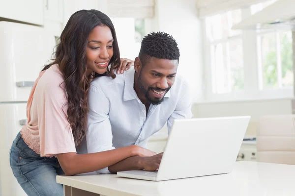 Pareja feliz usando su portátil — Foto de Stock