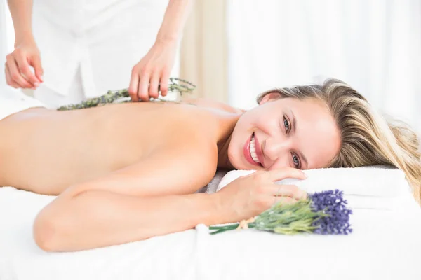 Loira deitada na mesa de massagem com lavanda — Fotografia de Stock