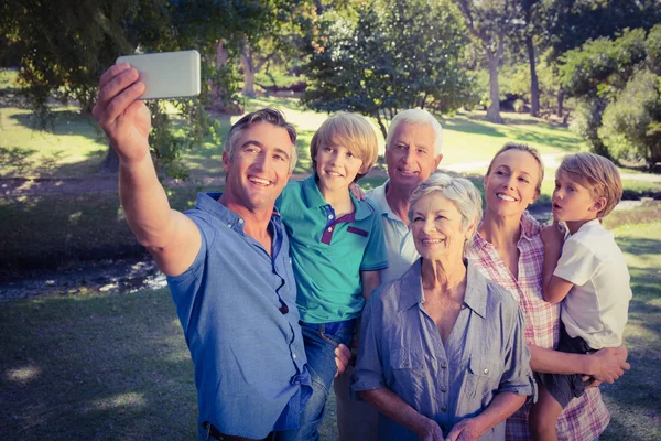 Família feliz tirando uma selfie no parque — Fotografia de Stock