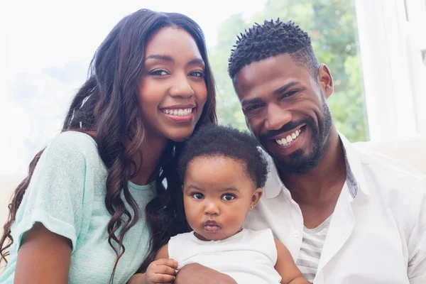 Padres felices con la niña en el sofá — Foto de Stock