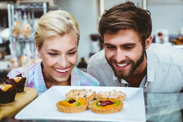 Linda pareja en una cita mirando pastel de frutas — Foto de Stock