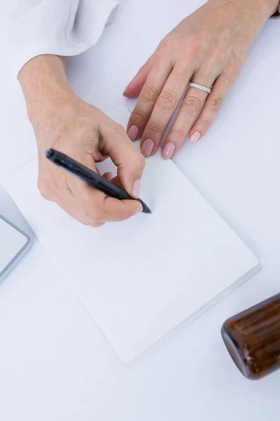 Doctor writing on a notepad — Stock Photo, Image