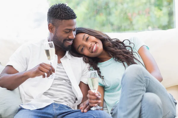 Par på soffan med champagne — Stockfoto