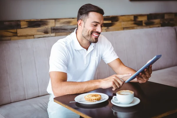 Young man having cup of coffee and pastry — Stock Photo, Image