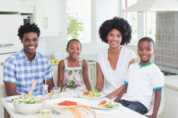 Glückliche Familie setzt sich zum gemeinsamen Abendessen zusammen — Stockfoto