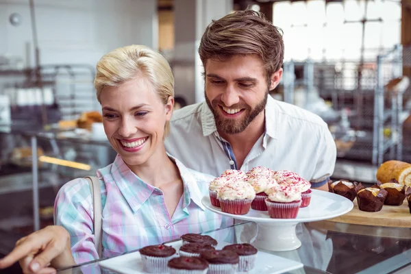 Couple mignon sur une date pointant des gâteaux au chocolat — Photo