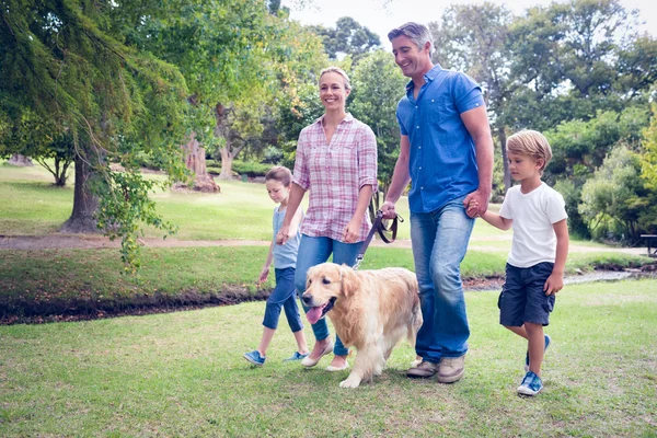 Família feliz no parque com seu cão — Fotografia de Stock