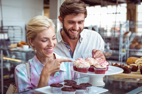 Linda pareja en una cita señalando pasteles de chocolate — Foto de Stock