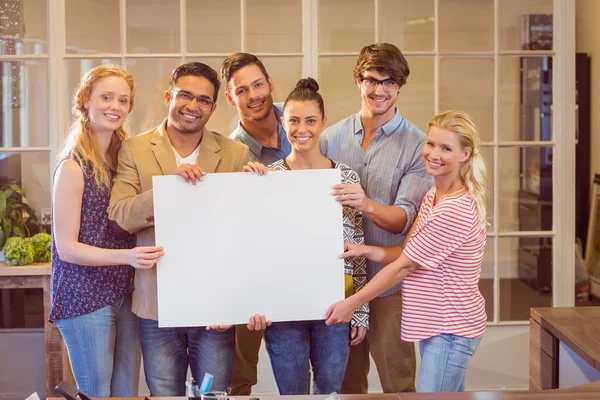Business team holding a white cardboard — Stock Photo, Image
