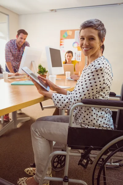 Креативна бізнес-леді в інвалідному кріслі за допомогою планшета — стокове фото