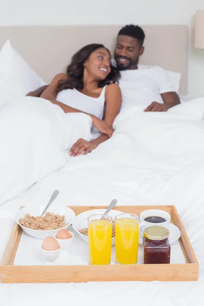 Casal relaxado tomando café da manhã na cama juntos — Fotografia de Stock