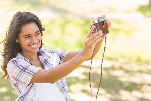 Bonita morena tomando una selfie con cámara retro en el parque — Foto de Stock