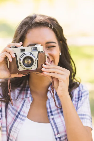 Půvabná brunetka v parku pomocí retro fotoaparát — Stock fotografie