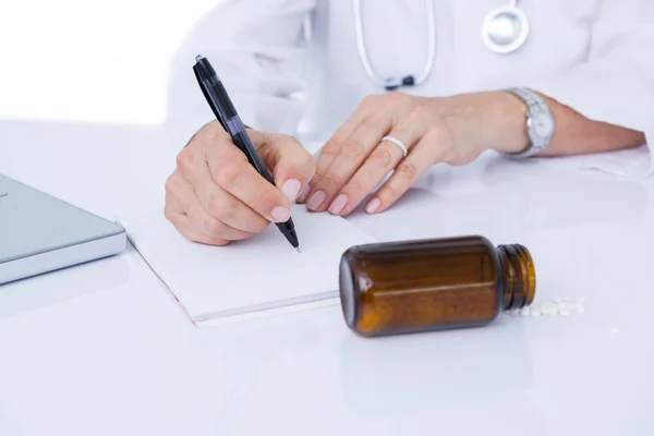 Doctor writing on a notepad — Stock Photo, Image