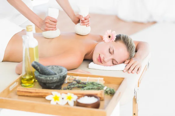 Blondine genießt Kräuterkompresse-Massage — Stockfoto