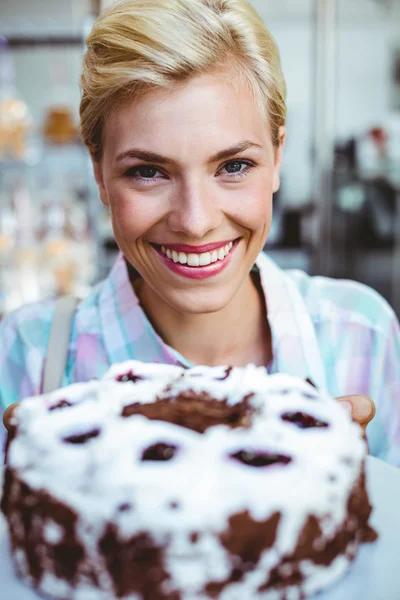 Όμορφη γυναίκα κοιτάζοντας ένα κέικ σοκολάτας — Φωτογραφία Αρχείου